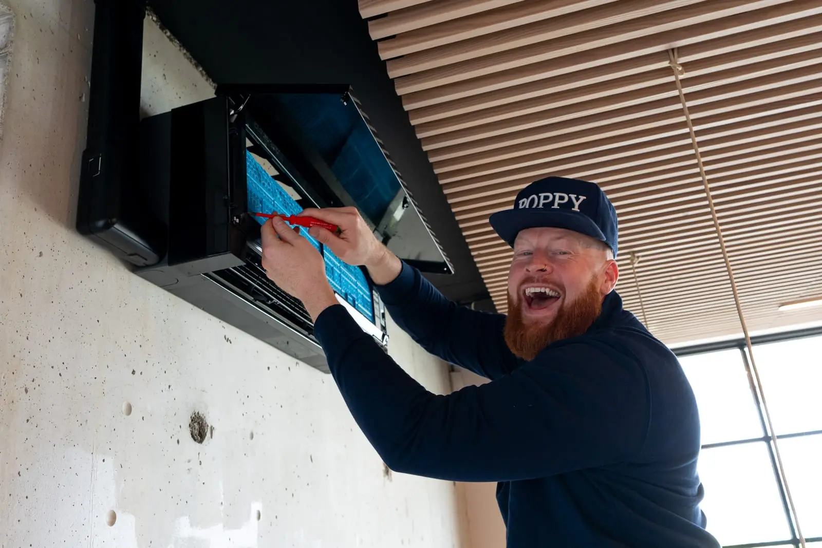 Monteur van Poppy Cool bevestigt een plafond-inbouwunit